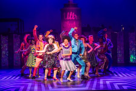 Hairspray Production photo. The company of Hairspray are all dancing together. The atmosphere is joyful.
