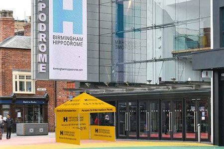 Access & Info Point - Hippodrome Square. Weekender Festival image. A small yellow tent on the rainbow square outside the Hippodrome.