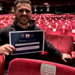 Person smiles while holding certificate with Name a Seat information.