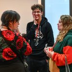 Four people stand together in conversation.