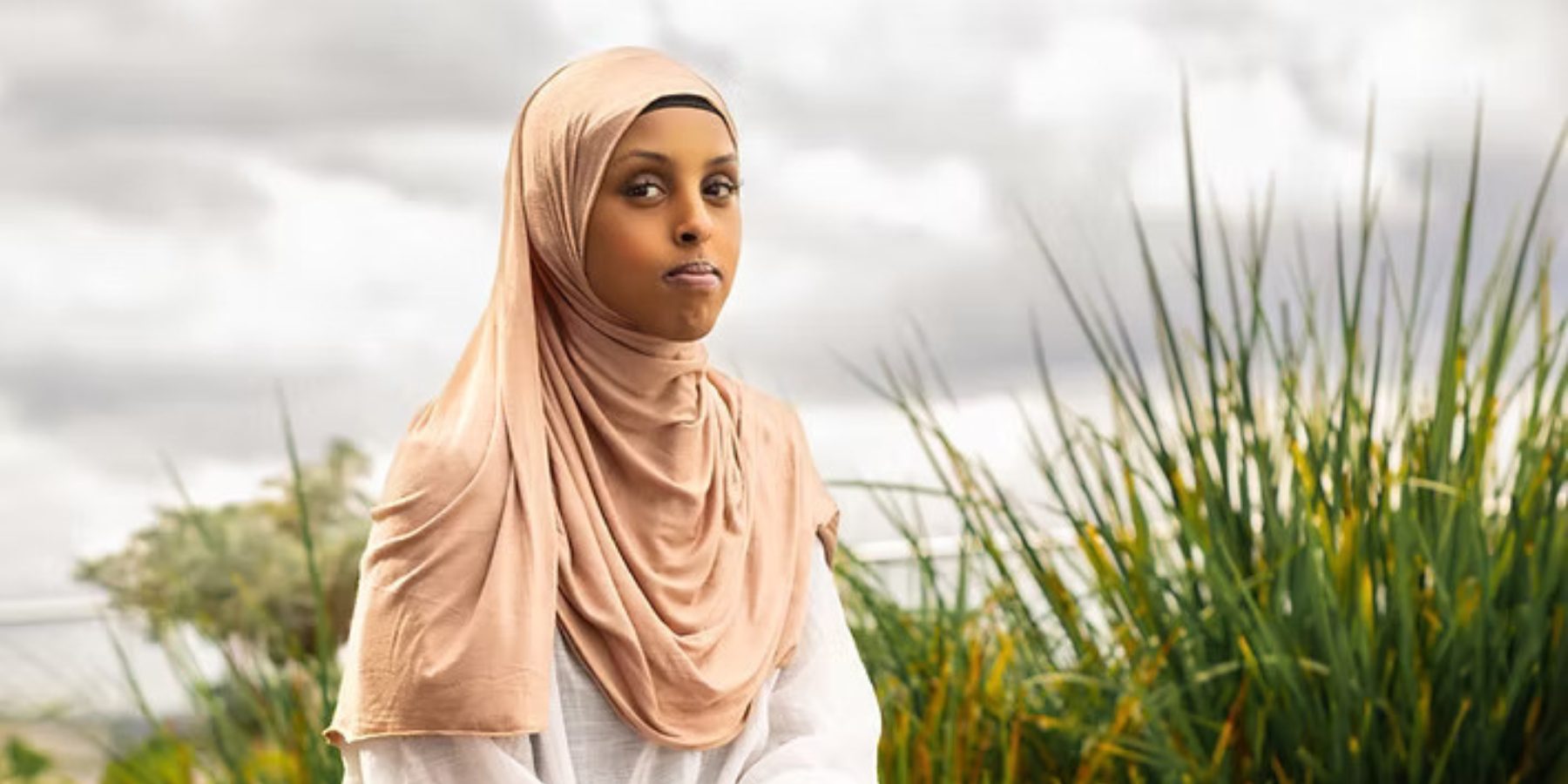 Poet Laureate Ayan Ade sitting in a garden.