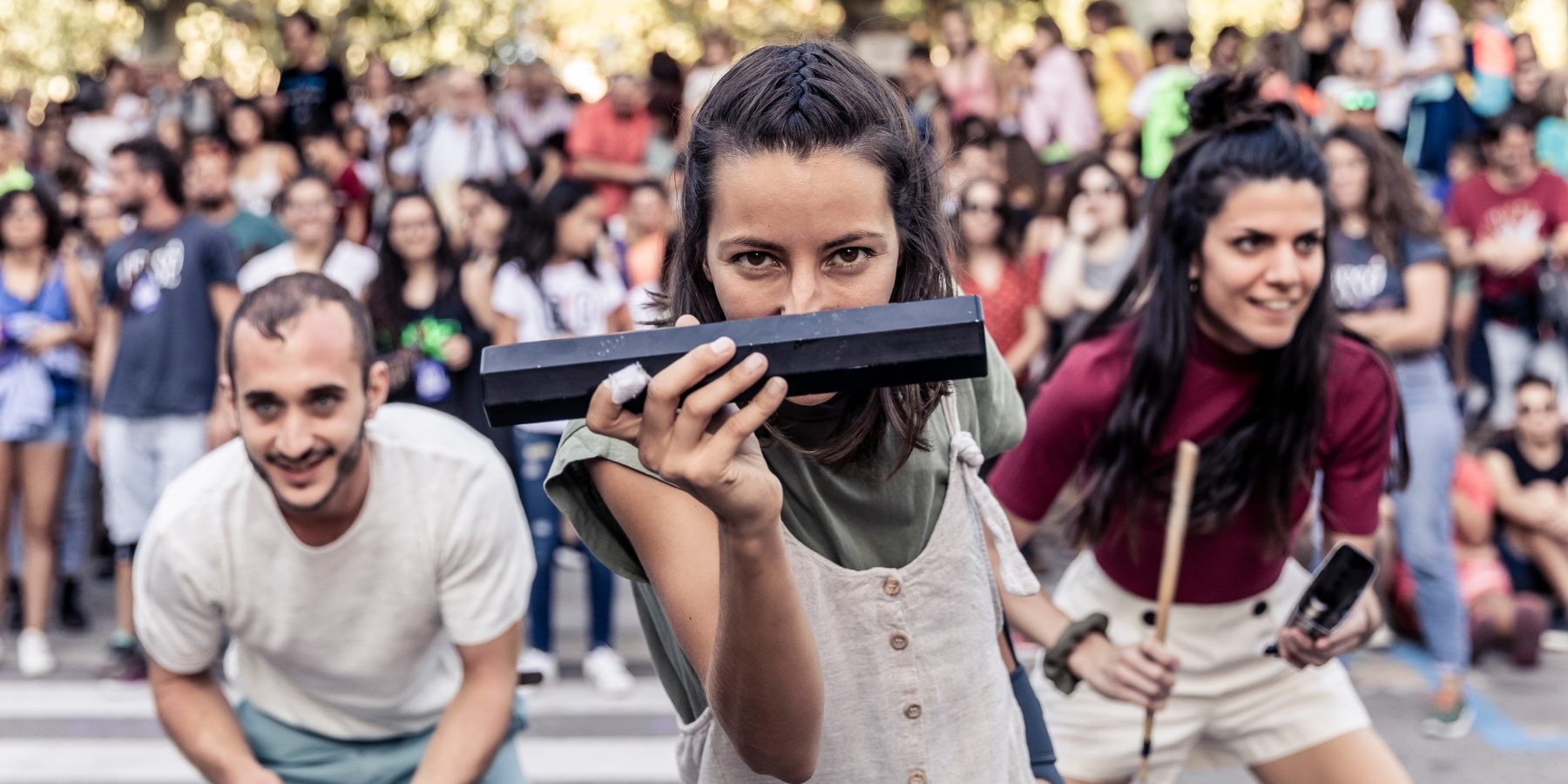 Three dancers performing in crowd engaging with the camera and audiences.