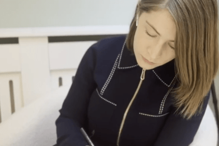 woman sat down writing in a book